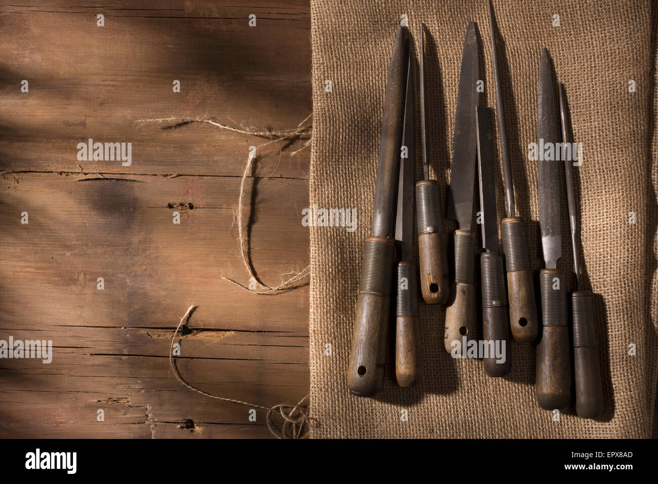 Argentiere di utensili disposti su un banco di lavoro, legno e tessuto di lino Foto Stock