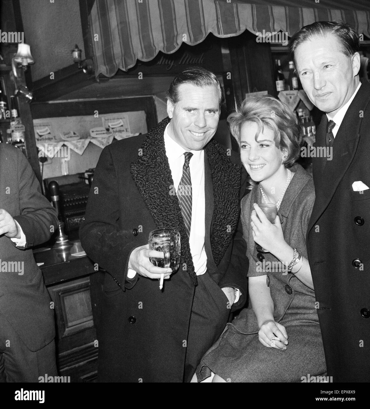 Kevin McClory, produttore di film, accompagnato dalla moglie ed ereditiera Bobo Sigrist, la High Court di Londra il 3° dicembre 1963. Kevin McClory celebra con un drink dopo aver citato in giudizio autore inglese Ian Fleming, Publisher Jonathan Cape Ltd e finanziere John Br Foto Stock