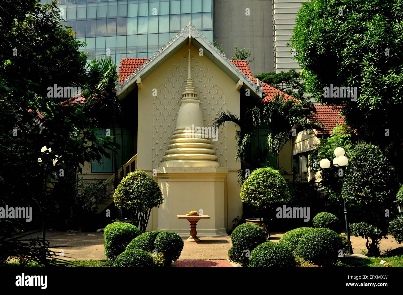 Bangkok, Thailandia: una metà chedi è costruito sul fianco di una casa monastica con bei giardini topiaria da al Wat Pathum Wanaram Foto Stock