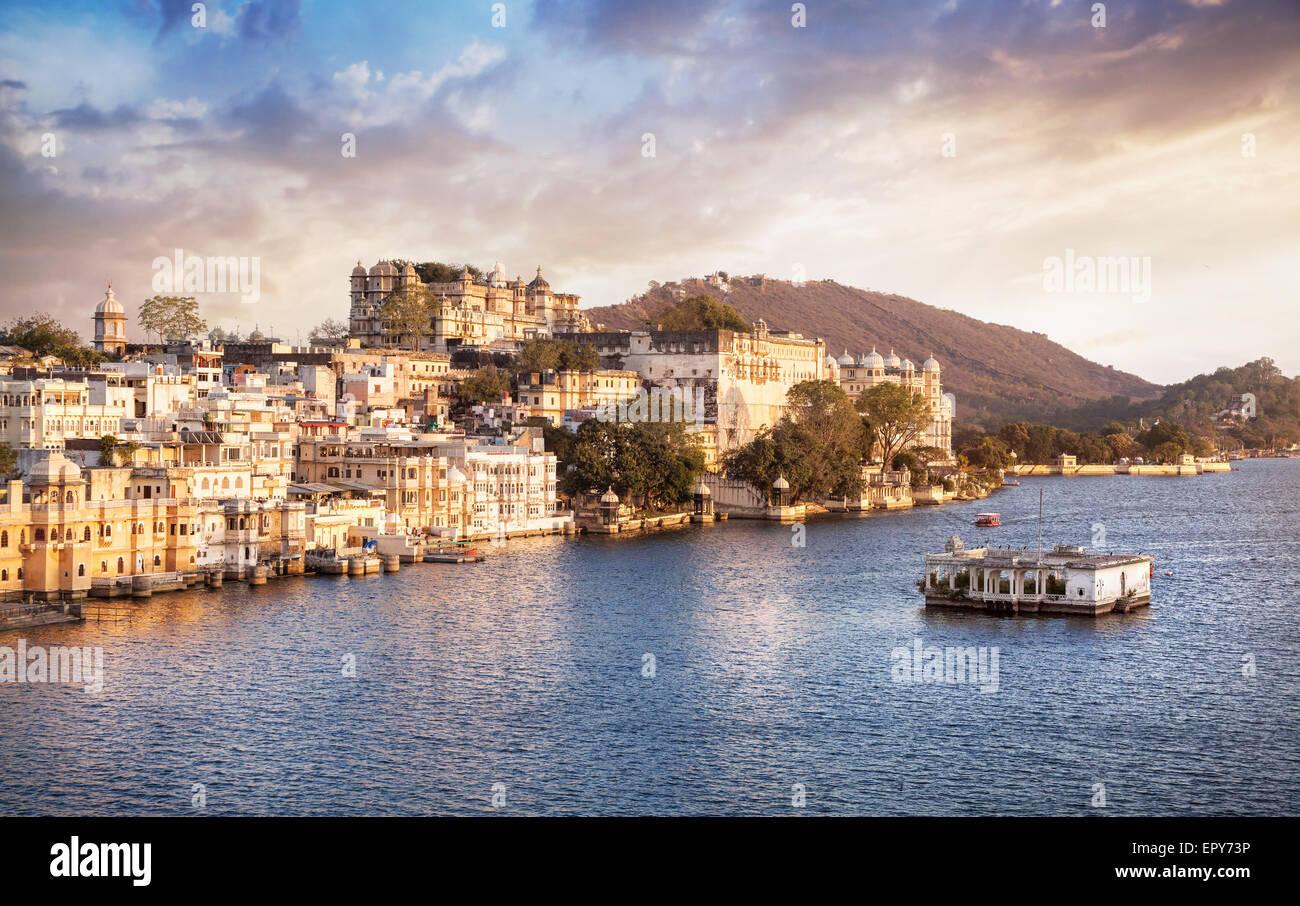Lago Pichola con City Palace vista a nuvoloso tramonto Cielo in Udaipur, Rajasthan, India Foto Stock