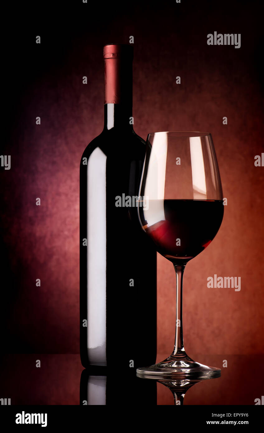 Il vino nel bicchiere e bottiglia su sfondo vinosa Foto Stock