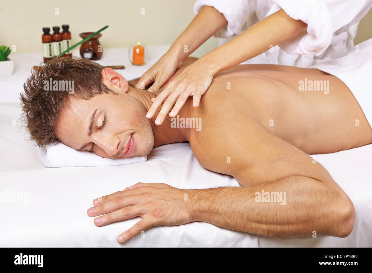 Uomo rilassato getting massaggio tailandese per il suo ritorno in una day spa Foto Stock