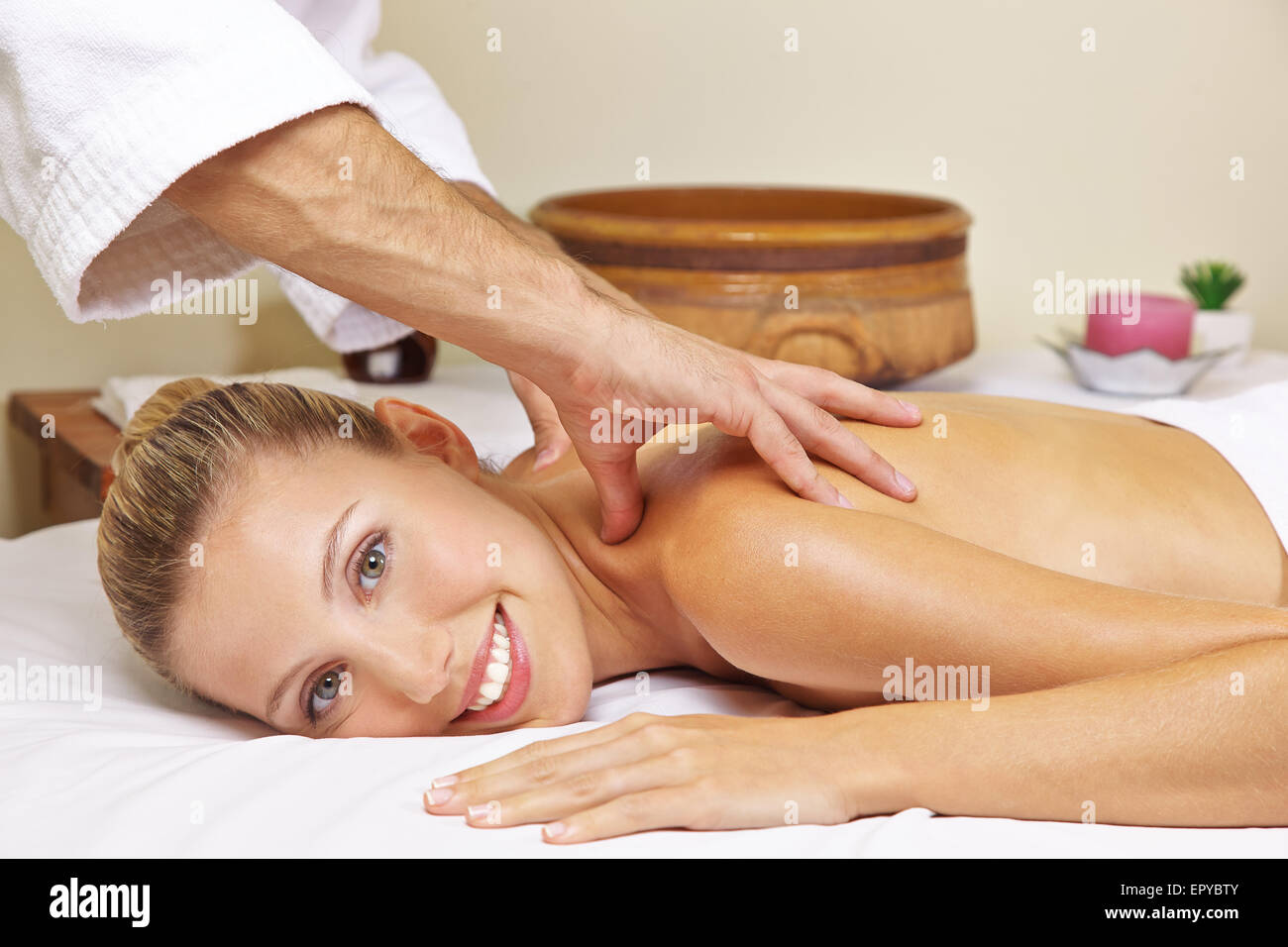 Donna sorridente getting massaggio alla schiena in salute resort spa Foto Stock