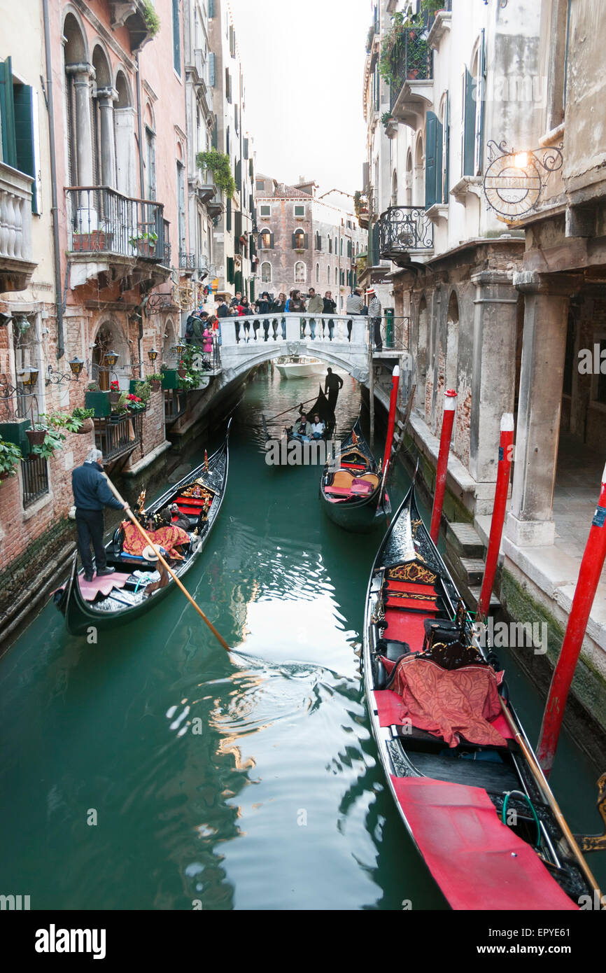 Uno stretto canale con gondole attraversando a Venezia, Italia Foto Stock