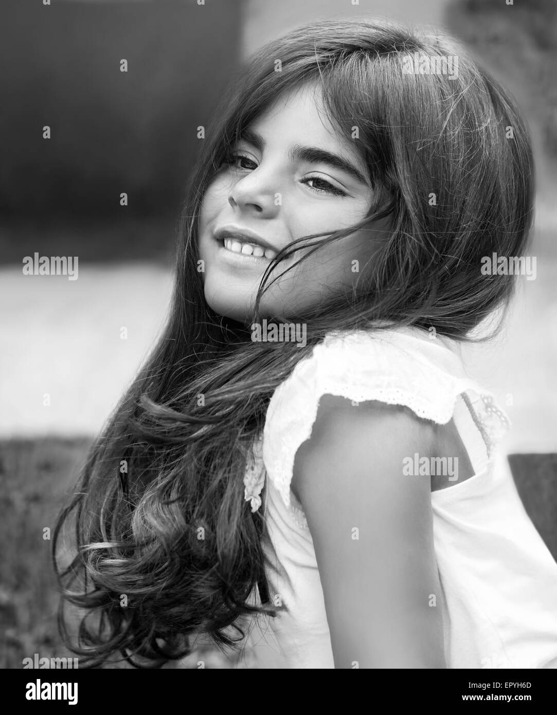 Moda foto in bianco e nero di una bellissima bambina di divertirsi nel parco, primo piano sulla faccia felice Foto Stock