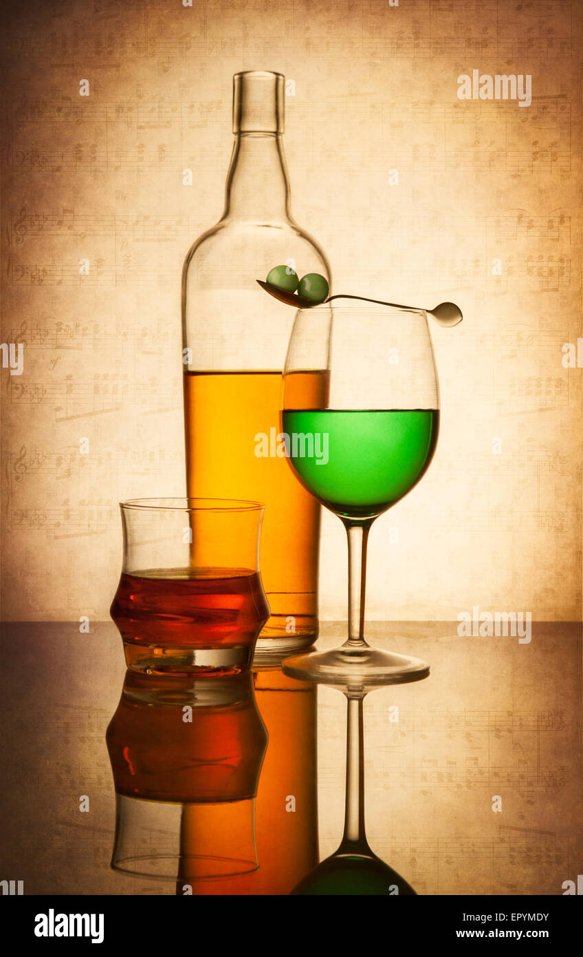Ancora vita composizione con bicchieri e bottiglie riempite con liquidi colorati sulla luce sfondo testurizzata Foto Stock