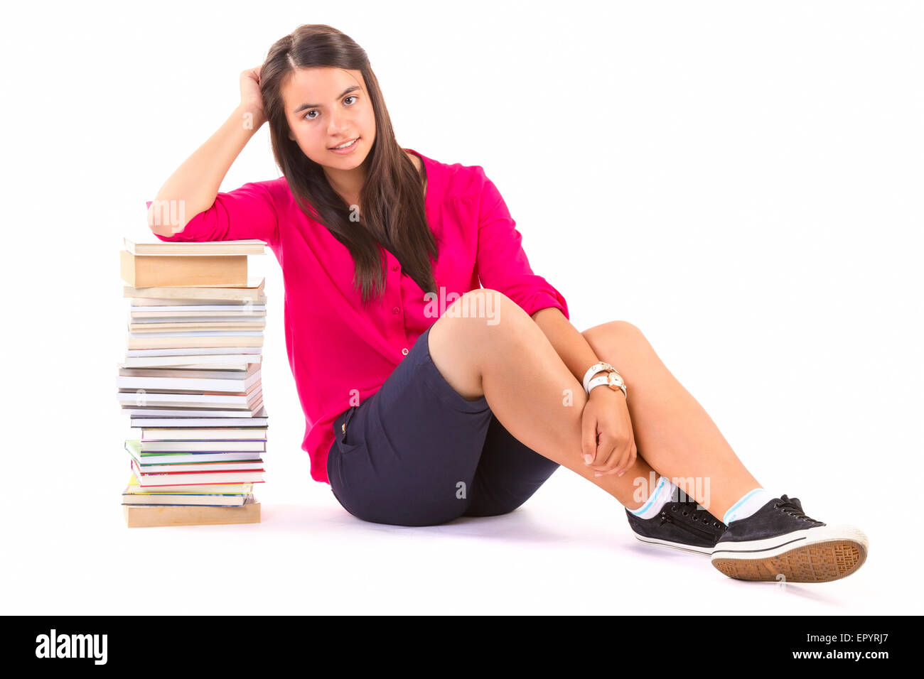 Giovane studente ragazza con pila di libri su sfondo bianco Foto Stock