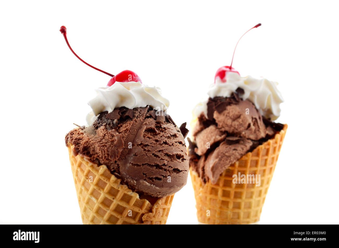 Concetto di estate Cioccolato e gelato alla vaniglia cono in cialda con panna e ciliegio con stelo in cima. Foto Stock