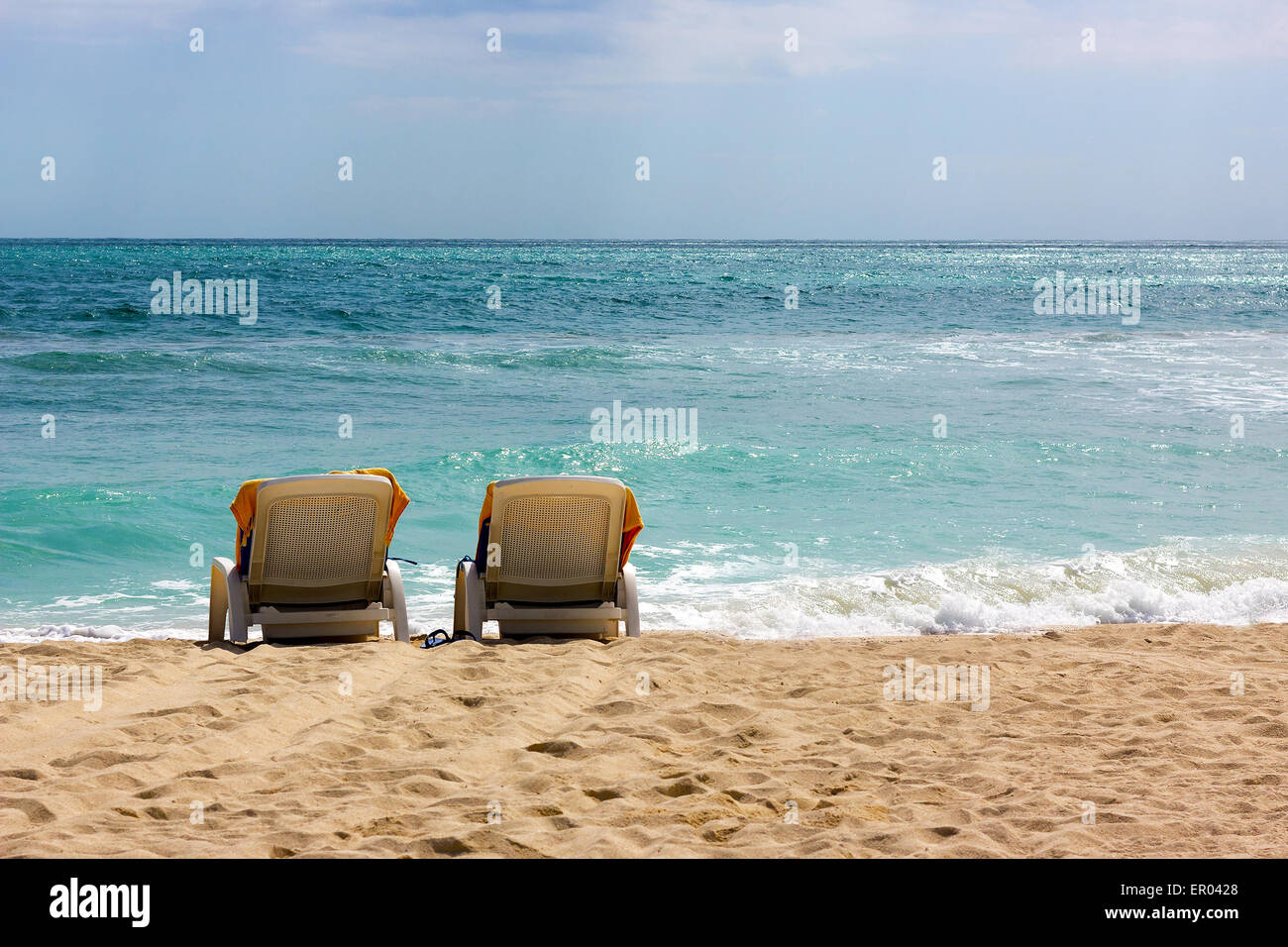 Lonely sedie a sdraio sulla spiaggia dell'oceano. Foto Stock