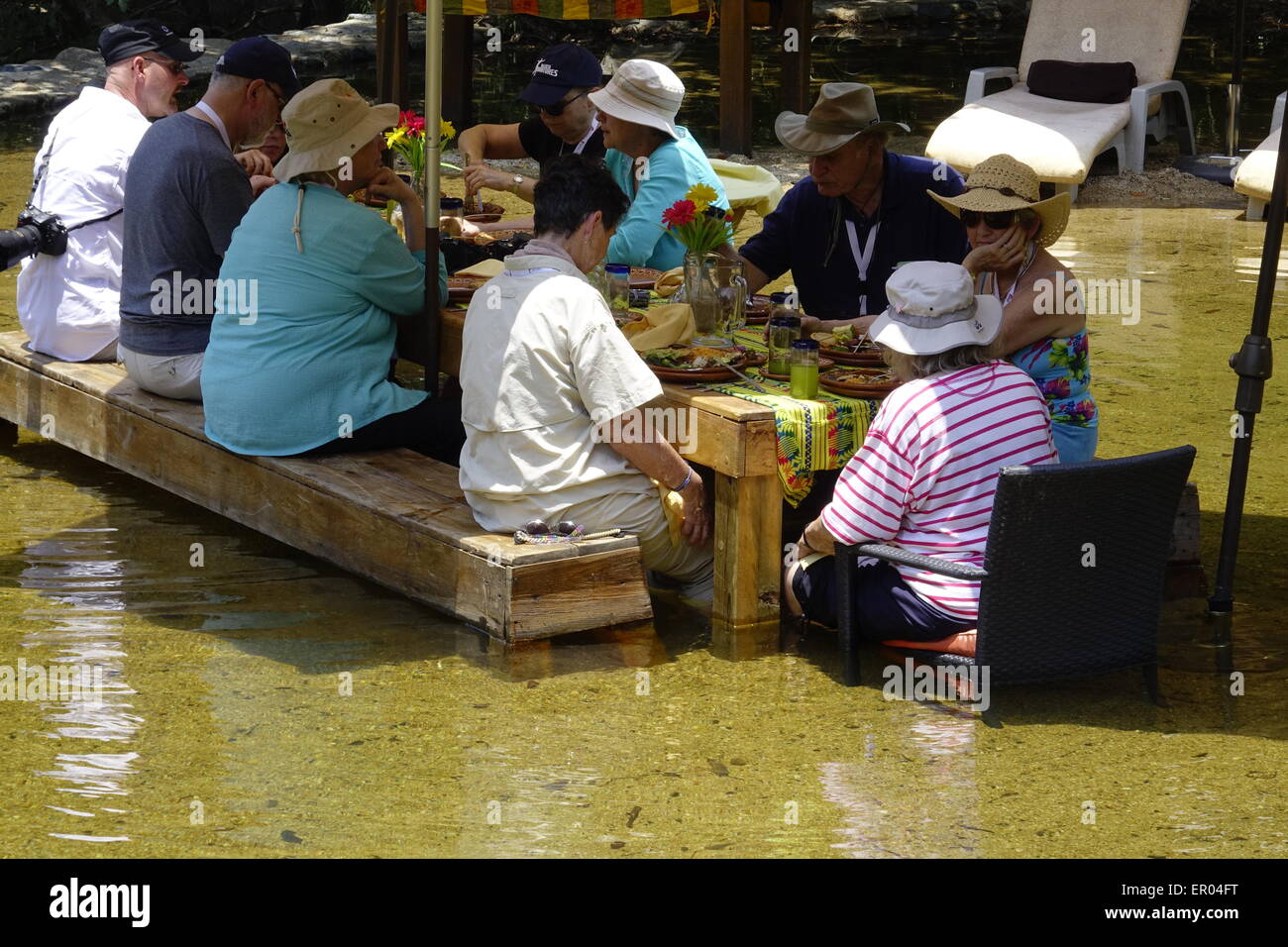 Gli ospiti a pranzo a Villa Azalea. Essi sono qui seduti in un chiaro, piscina poco profonda formata mediante raschiatura del fiume Foto Stock