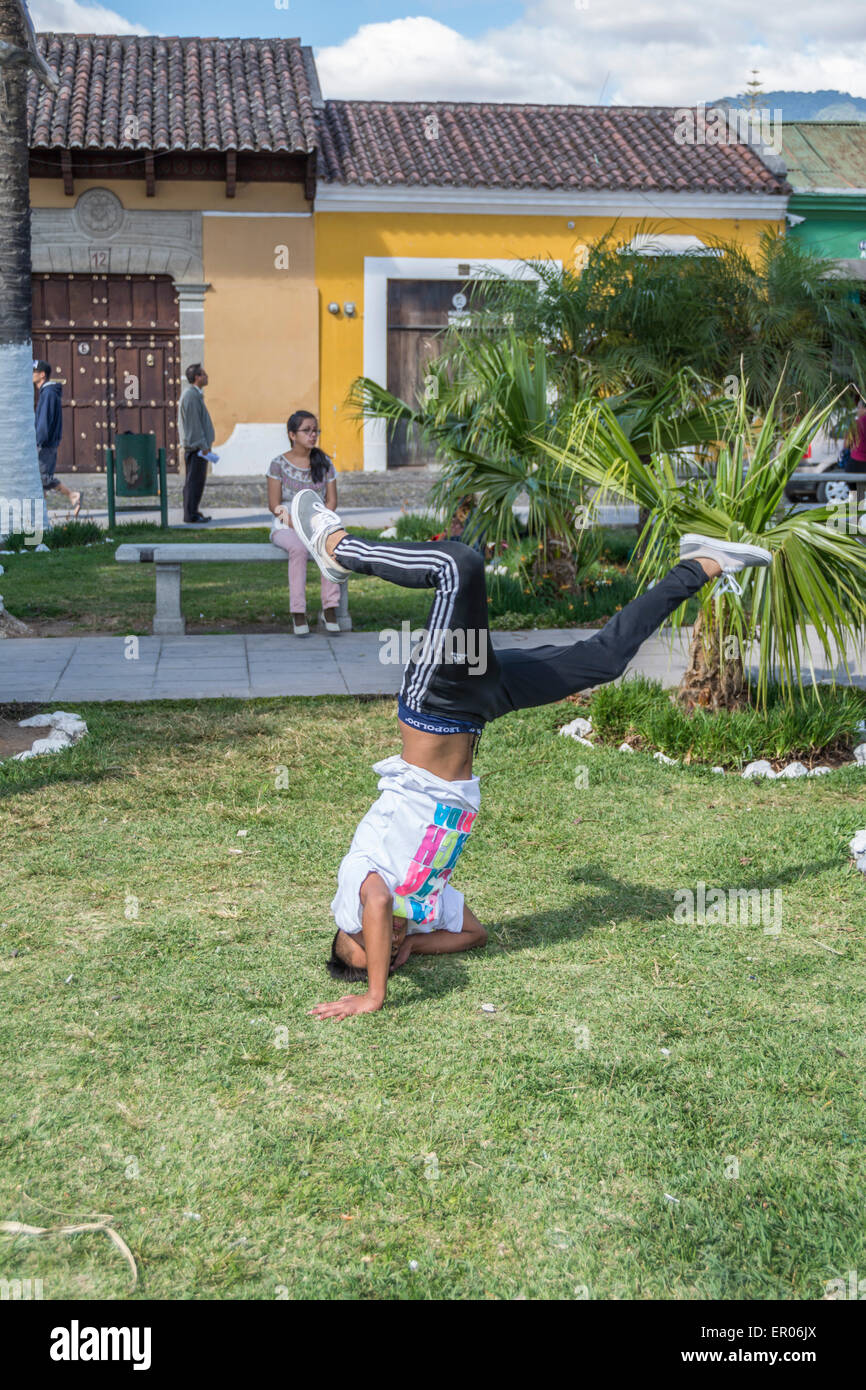 Ragazzo adolescente facendo un headstand in un parco in Antigua Guatemala Foto Stock