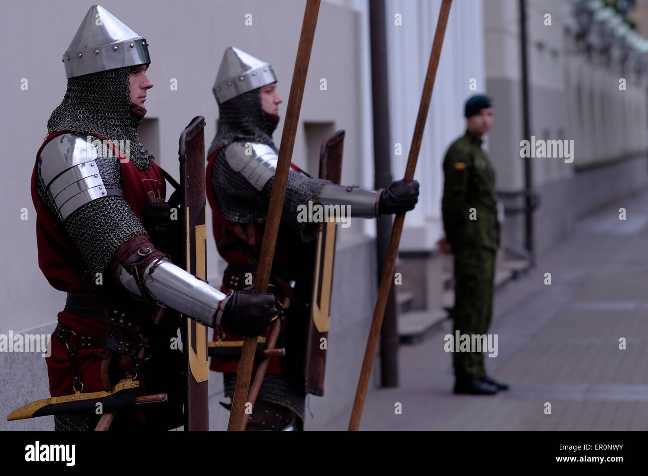 Gli uomini in cavaliere medievale vestito e un soldato di guardia al palazzo presidenziale nella città vecchia di Vilnius un Sito Patrimonio Mondiale dell'UNESCO e capitale della Lituania. Foto Stock