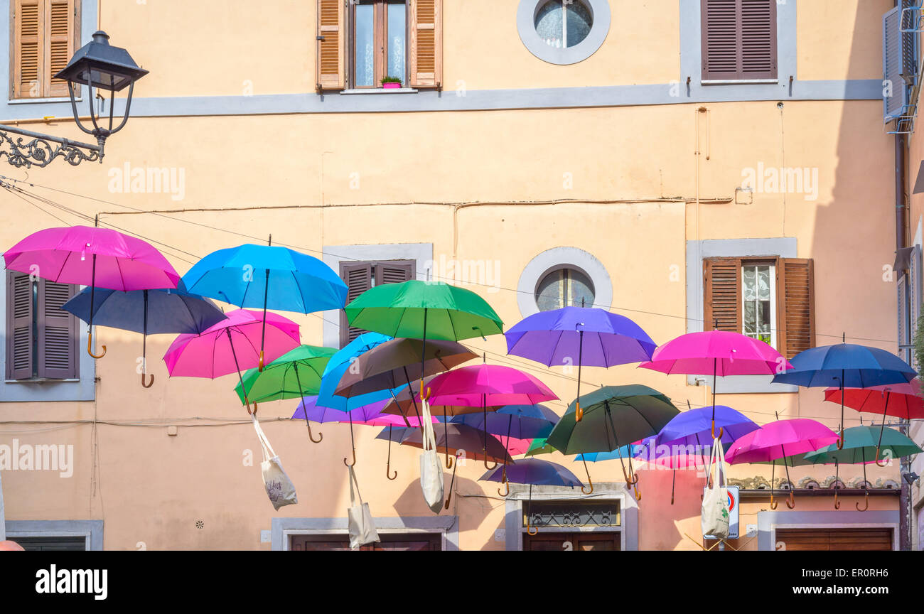 Ombrelloni colorati appesi da una strada durante un villaggio di festa Foto Stock