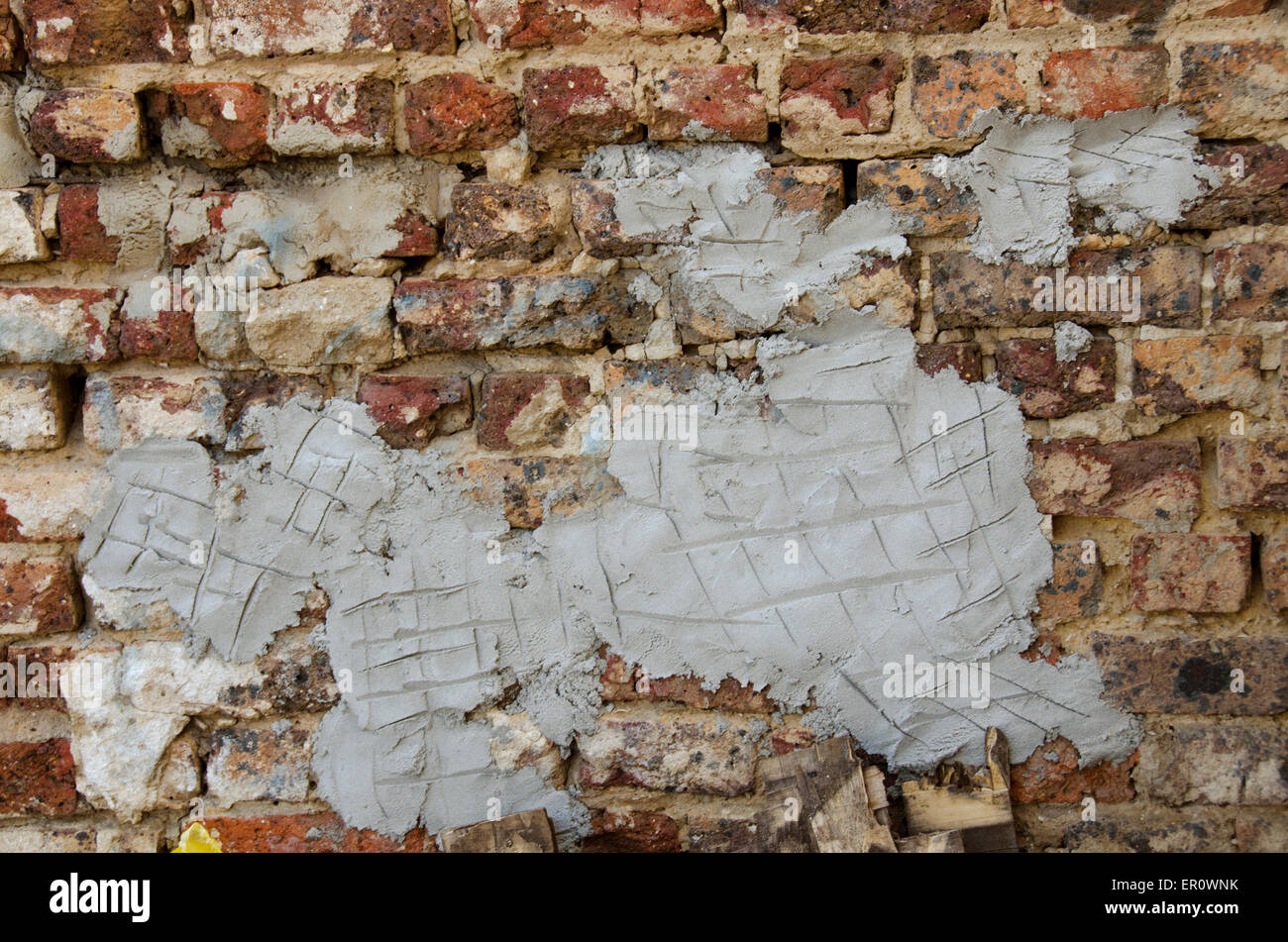 Vecchia parete in muratura che mostra molto usurati, esposto di mattoni e malta Foto Stock