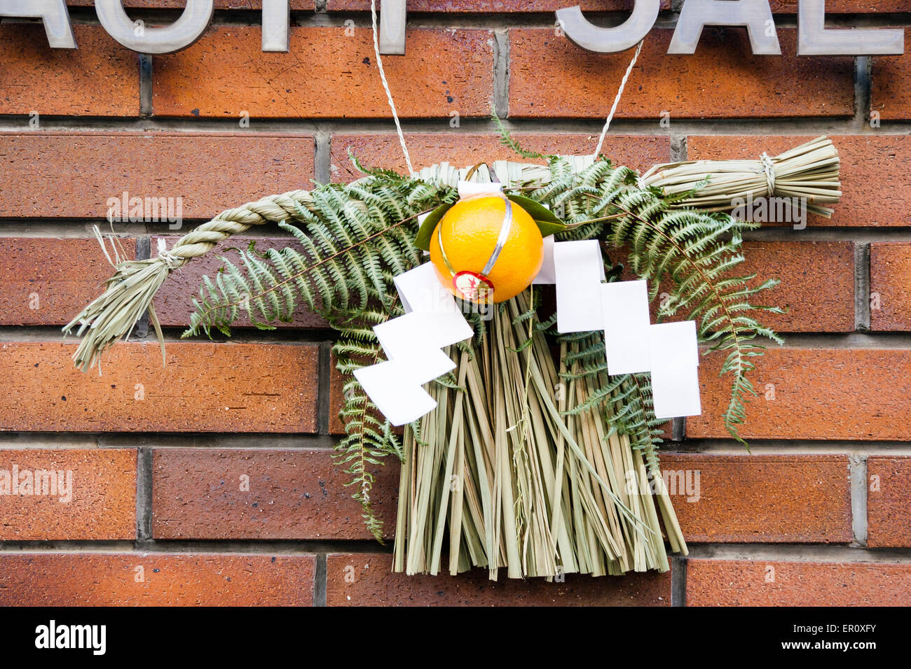 Tipico decorazione di nuovo anno, Shimekazari, posto da porte esterne in Giappone. In paglia di riso, shimenawa, strisce di carta a zigzag, foglie di shide e pino. Foto Stock