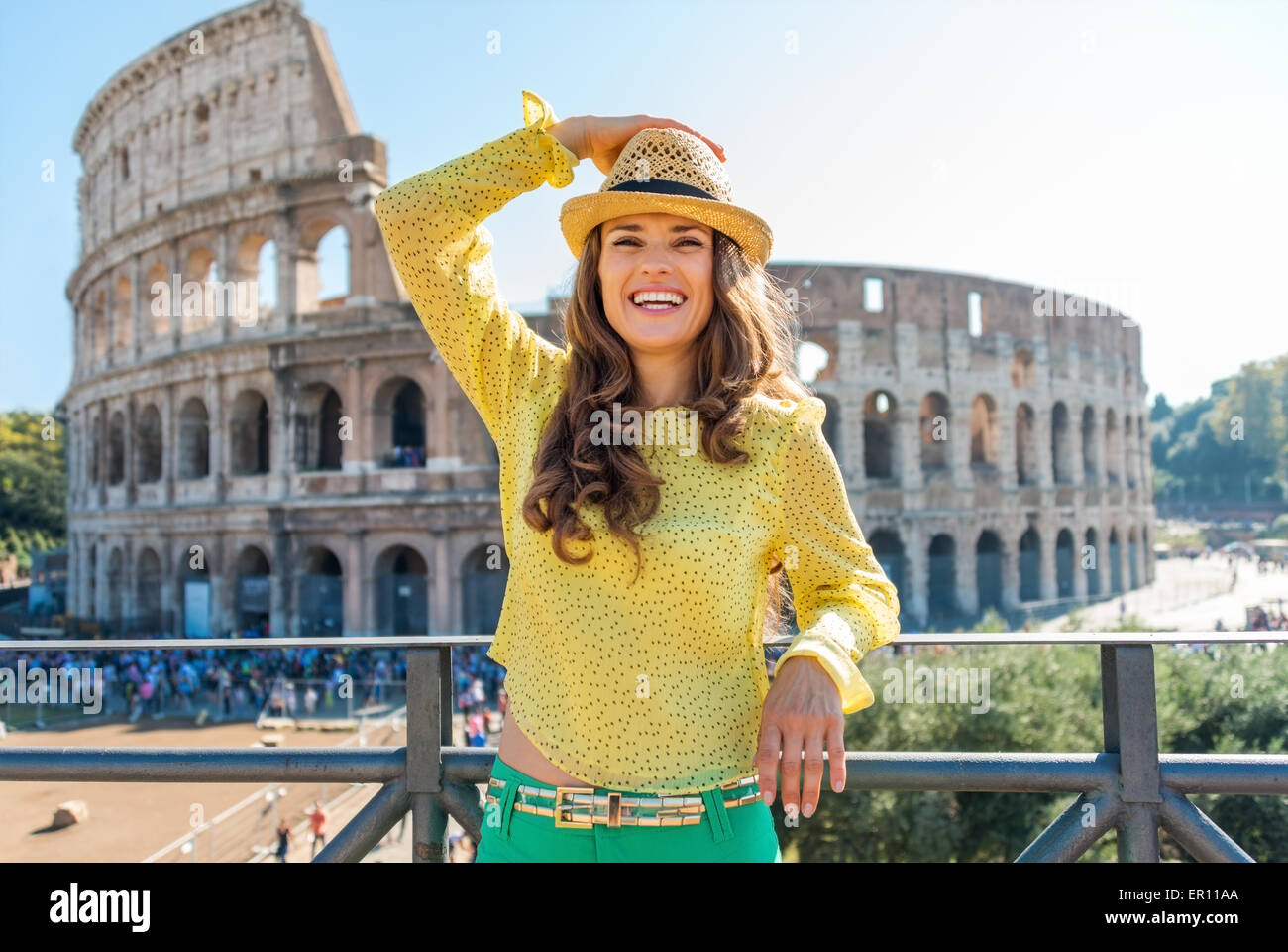 Un turista è in piedi, tenendo il suo cappello, guardando in lontananza e ridere. Ella è lieto di essere a Roma. Nel dis Foto Stock