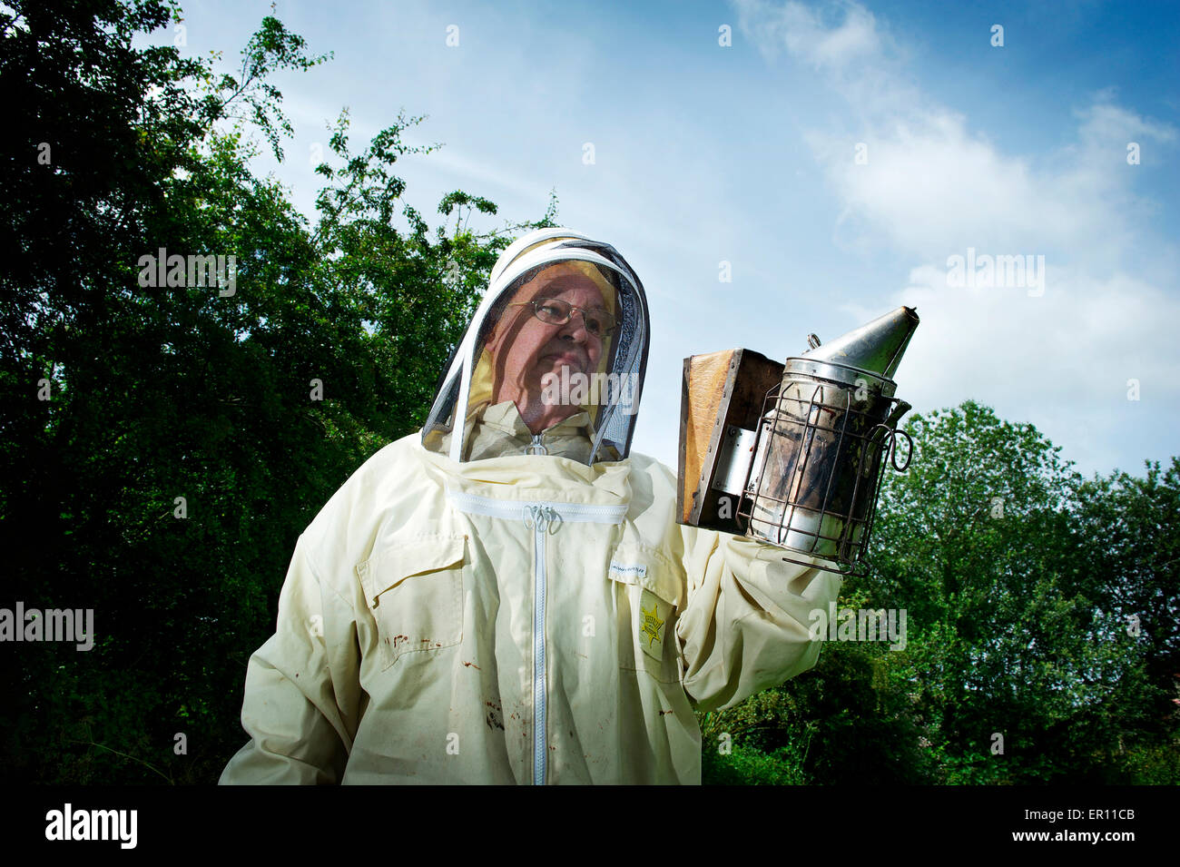 Bob Abete rosso tenendo il fumatore, pronto per ispezionare i suoi alveari Foto Stock
