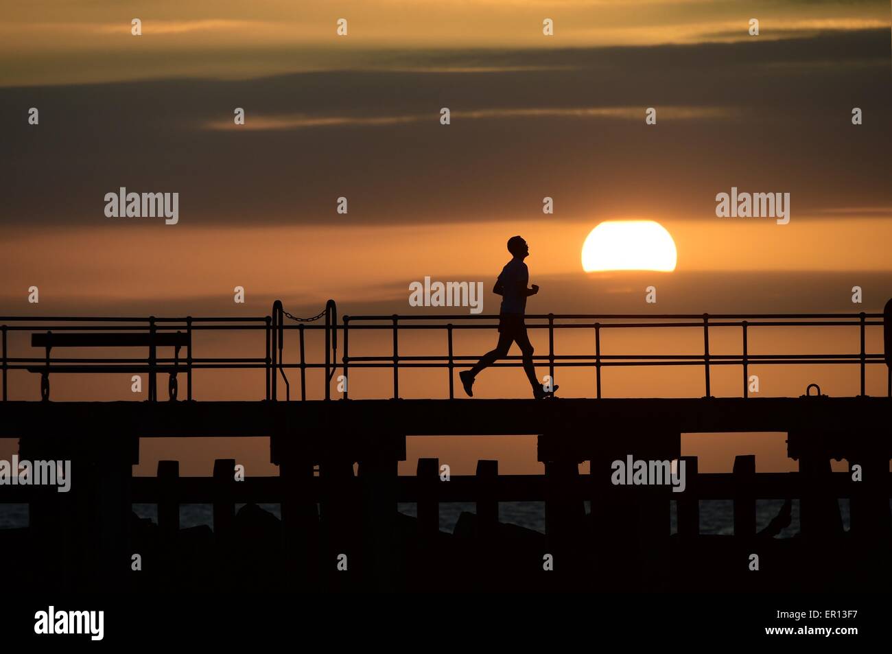 Regno Unito Meteo: Aberystwyth Wales UK domenica 24 maggio 2015 un solo uomo fa avanzare in silhouette contro il tramonto su Cardigan Bay alla vigilia del maggio lunedì festivo in Aberystwyth sulla West Wales coast Photo credit: keith morris / Alamy Live News Foto Stock