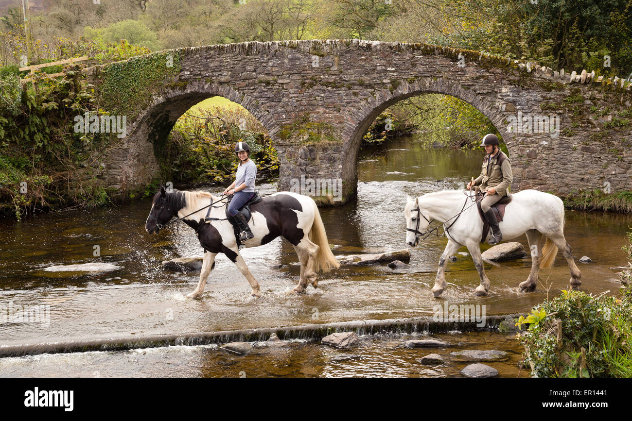 Cavalieri attraversando il guado del Oriente Lyn river a Malmsmead e Lorna Doone Farm Exmoor Somerset / confine DEVON REGNO UNITO Foto Stock