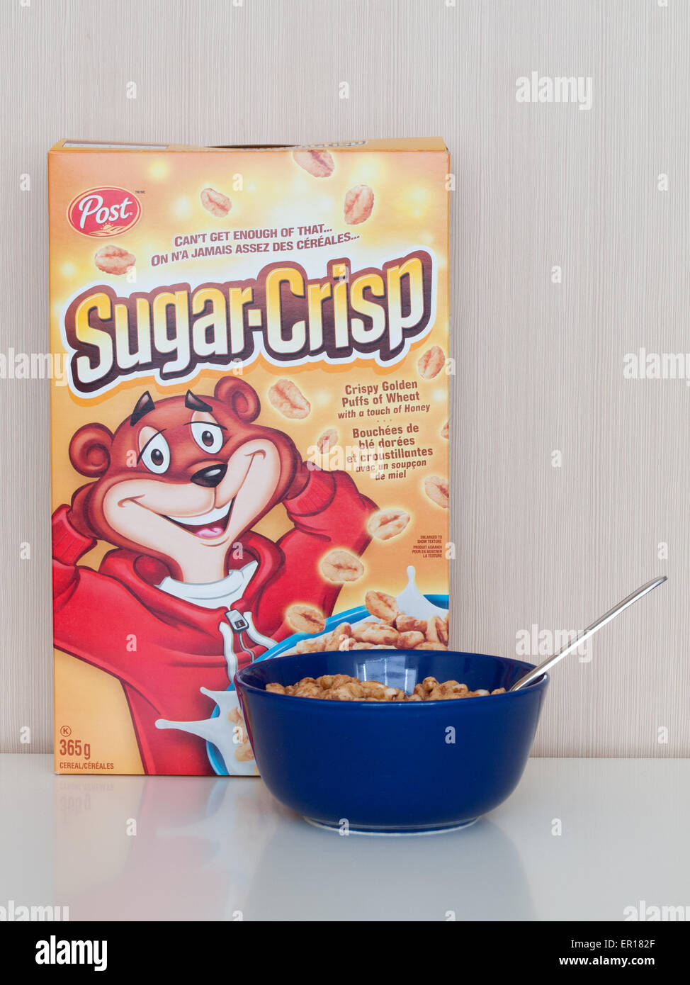 Una scatola e una ciotola di croccante di zucchero (Golden Crisp), una colazione a base di cereali effettuate da Post di cereali che consiste di zuccherato grano soffiato. Foto Stock
