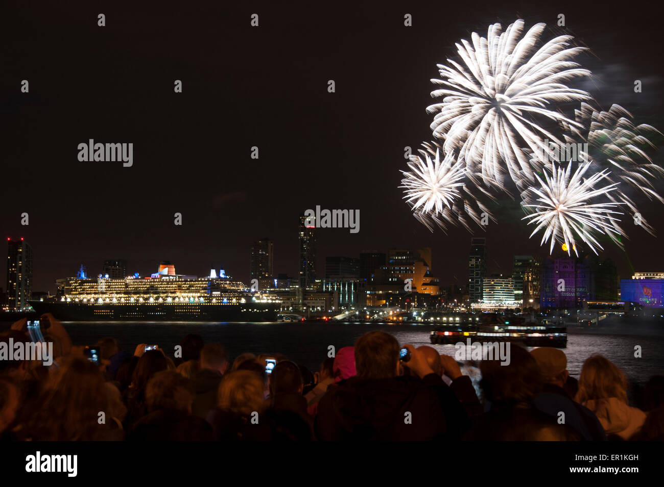 Cunard Line spedizione celebra il suo 175mo anniversario con un evento chiamato una città magnifica. Tre regine di Cunard - si tratta di tre navi - Queen Mary 2 Queen Victoria e la Queen Elizabeth vela in Liverpool insieme. La foto mostra la Cunard nave Queen Mary 2 nave contro la famosa in tutto il mondo Cunard Building, centro sul lungomare di Liverpool illuminato da fuochi d'artificio nella celebrazione. A sinistra del centro è il Royal Liver Building e alla destra del centro è il porto di Liverpool Building Foto Stock