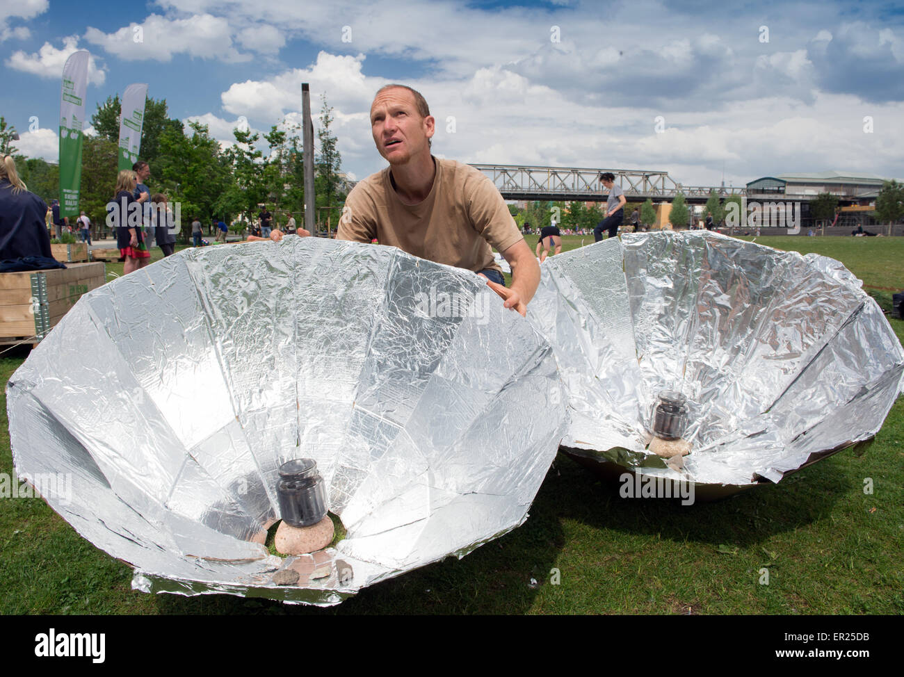 Berlino, Germania. 25 Maggio, 2015. Rolf allinea due auto-costruito solar ombrelloni per la cottura di pasta e salsa di pomodoro al Park am Gleisdreieck a Berlino, Germania, 25 maggio 2015. La preparazione del pasto era parte del 'No picnic rifiuti" tenuto dal tedesco Ministero per lo sviluppo e l' Institut für avanzati studi di sostenibilità (IAS) volti al salvataggio di generi alimentari da guastandosi. Foto: SOEREN STACHE/dpa/Alamy Live News Foto Stock