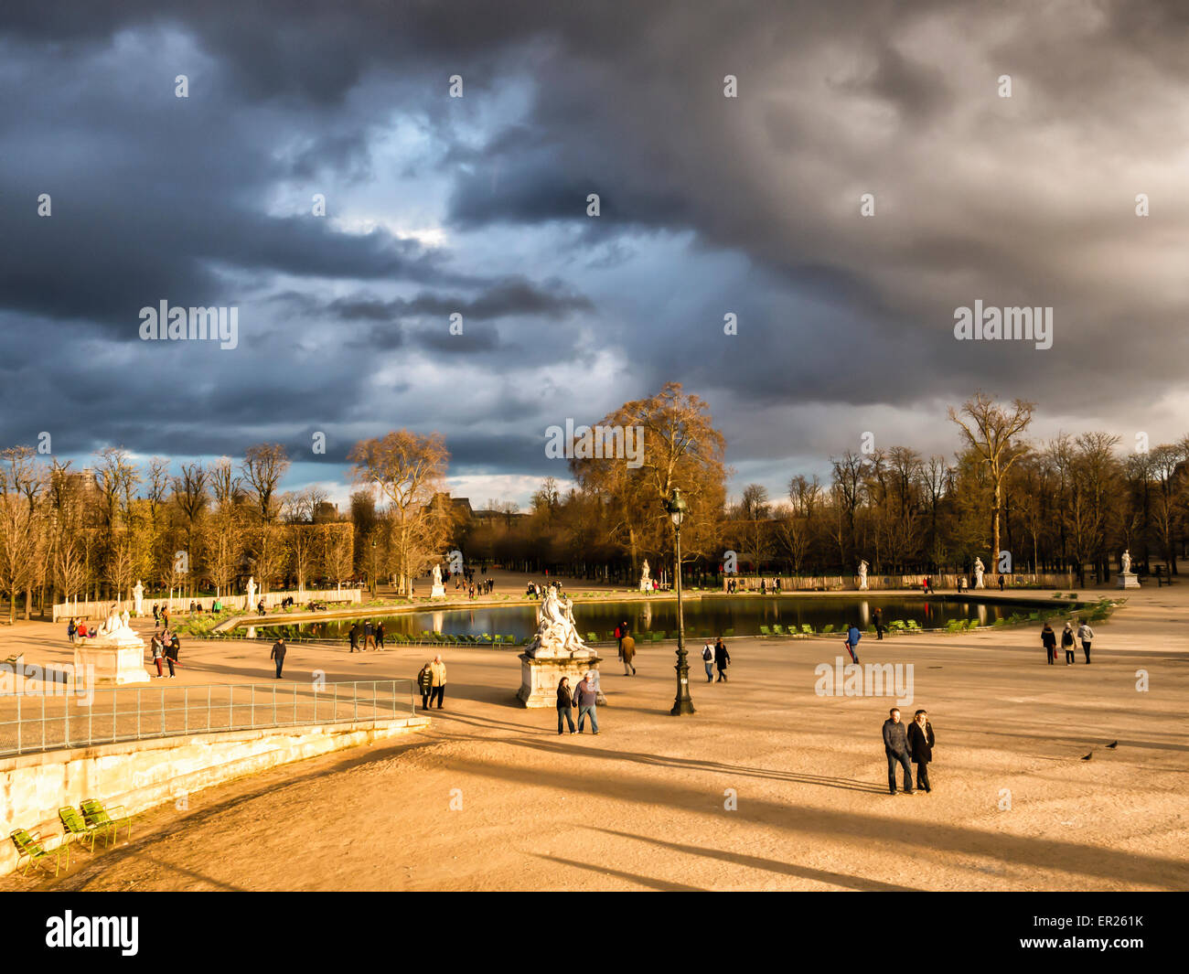 Parigi, Tuilerires Garden - Bassin ottagonale pond, sculture, la luce solare e la drammatica nuvole di tempesta Foto Stock