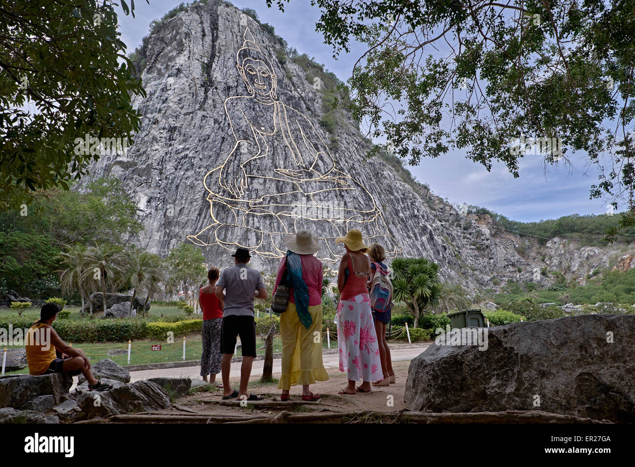 Gruppo di turisti thailandesi che ammirano la vista dell'inlay laser di Buddha unico a Khao Chee Chan montagna sacra Pattaya Thailandia S. E. Asia Foto Stock