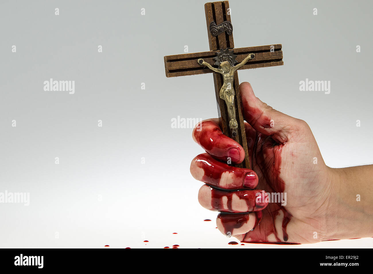 Lato coperto di sangue è in possesso di una croce, bianco e grigio gradiente dello sfondo. Foto Stock