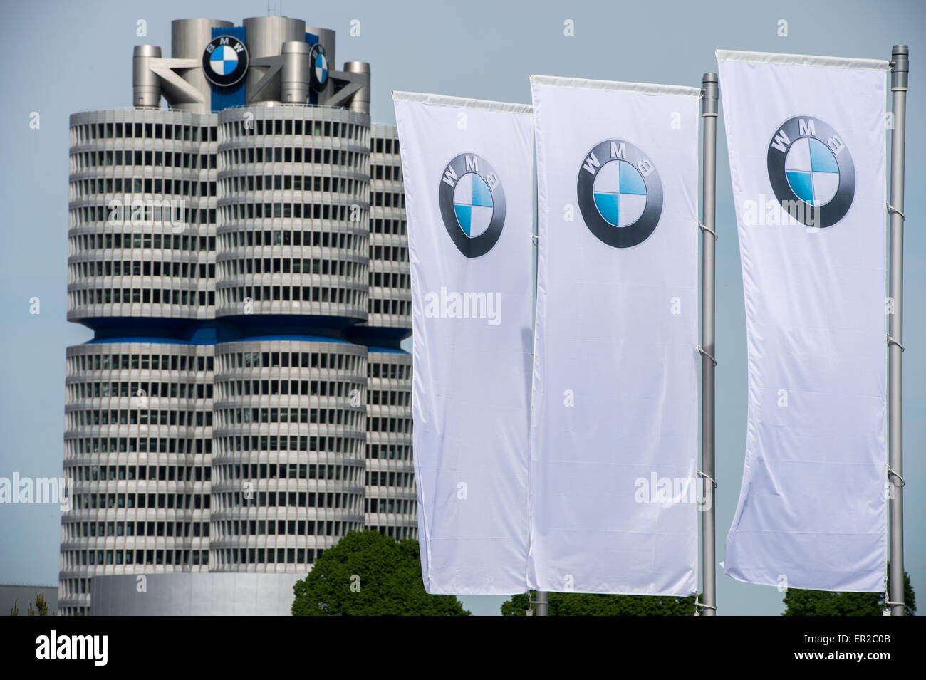 Monaco di Baviera, Germania. 11 Maggio, 2015. Le bandiere con il logo di tedesco automobile manufacturing company BMW sono nella foto accanto alla sede aziendale, la torre di BMW a Monaco di Baviera, Germania, 11 maggio 2015. La BMW ha tenuto la sua assemblea degli azionisti il 13 maggio 2015. Foto: Peter Kneffel/dpa/Alamy Live News Foto Stock