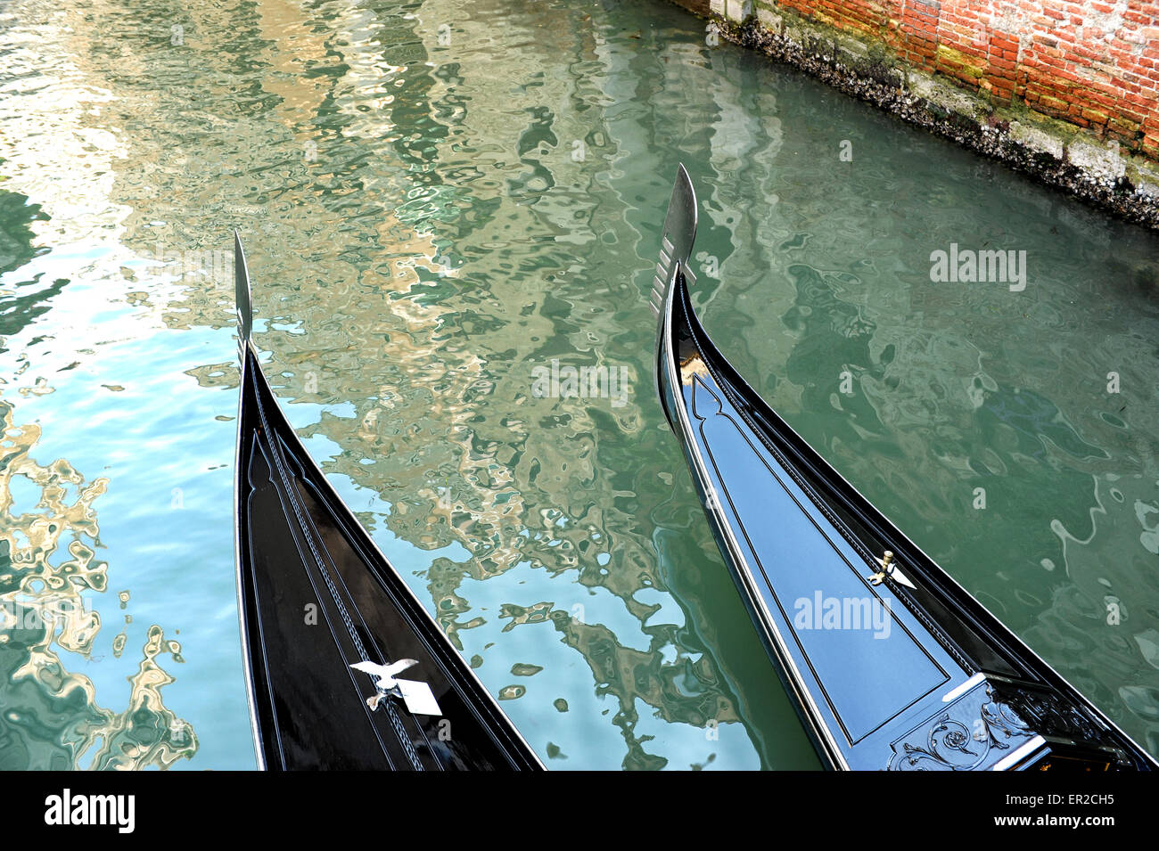 Vista dalla cima del prows di due gondole romantiche in un tranquillo canale veneziano, Venezia, Italia Foto Stock