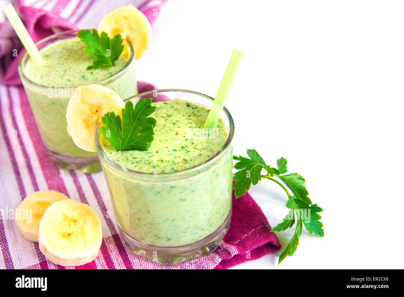 Freddo frullato verde con banana, yougurt, erbe e verdure isolati su sfondo bianco Foto Stock