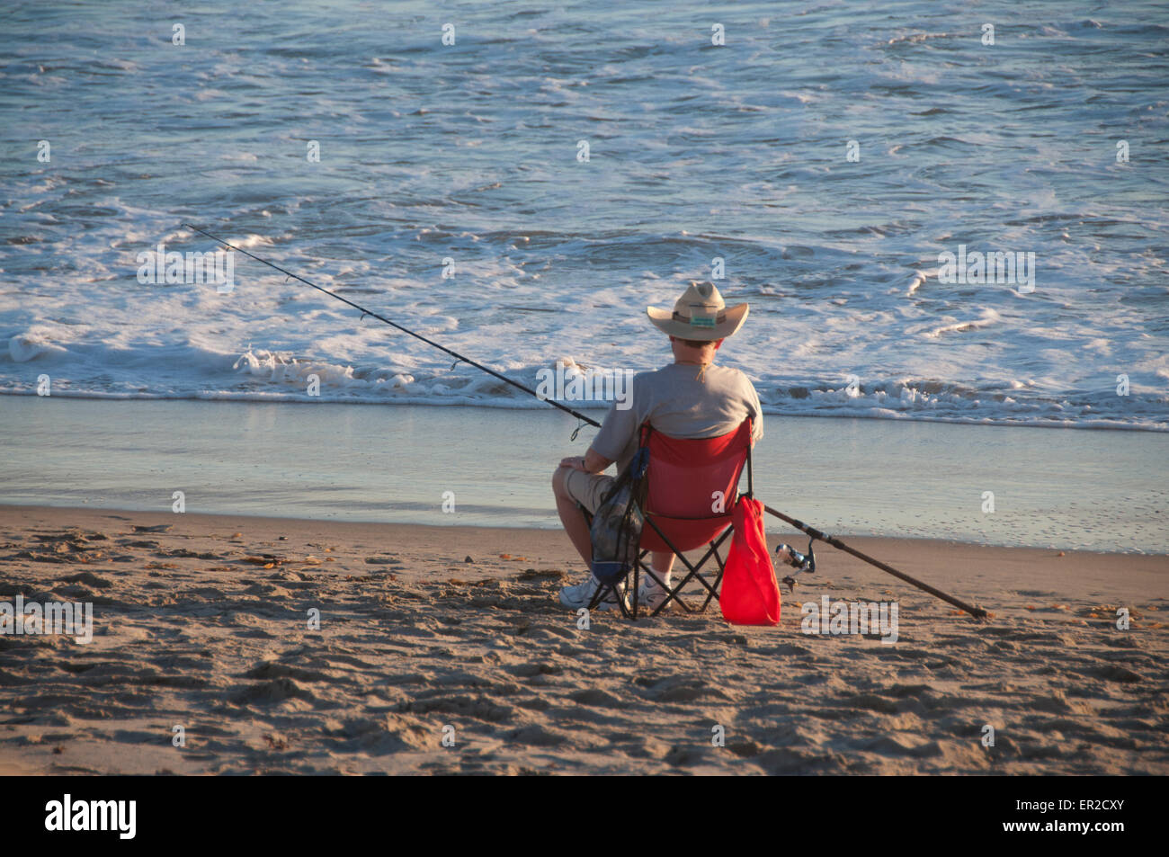 Fisherman seduta beach Foto Stock