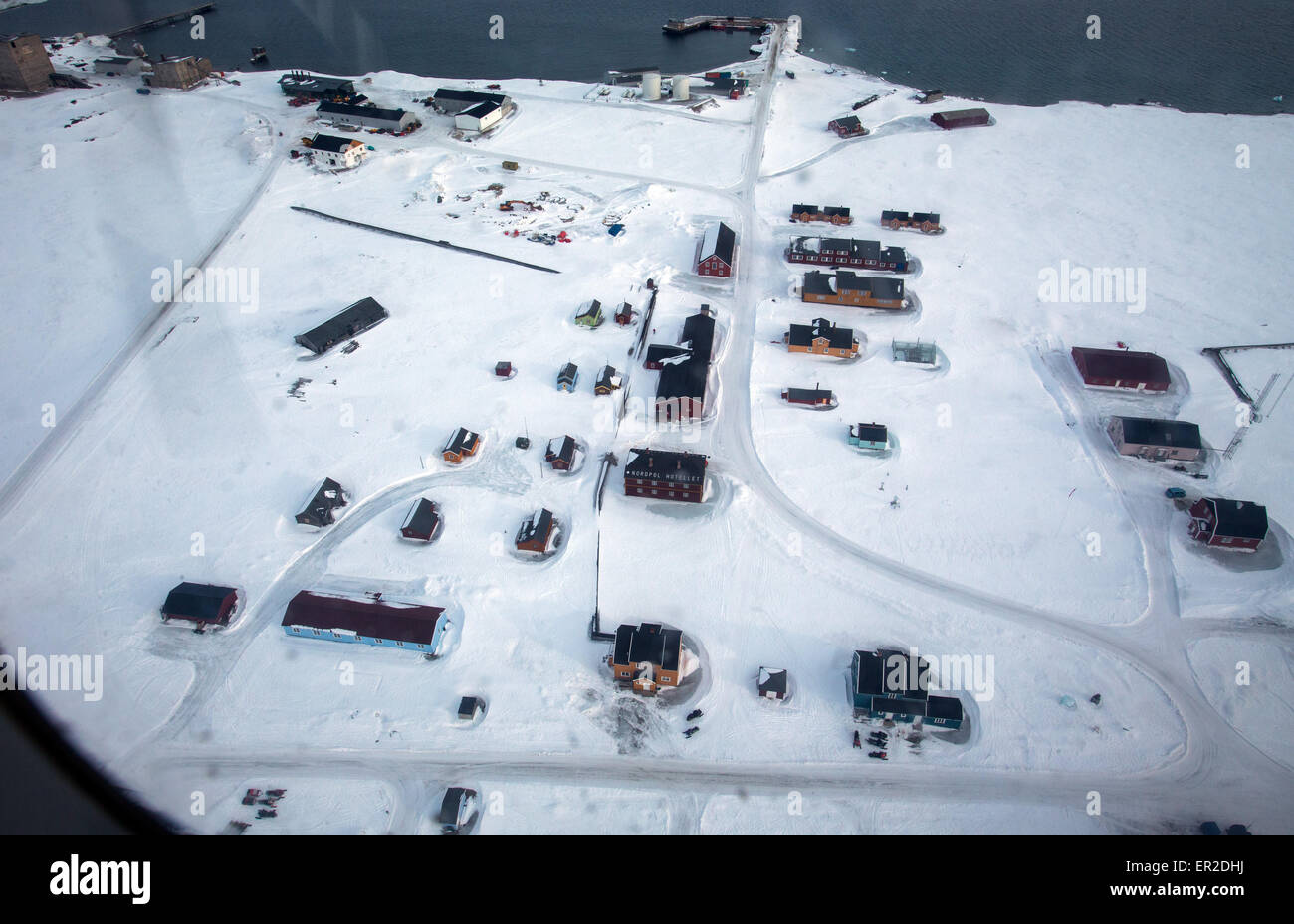 Una veduta aerea sparato da un aereo della stazione di ricerca Kings Bay in Ny-Alesund sull isola Spitsbergen, Norvegia, 10 aprile 2015. Arctic stazioni di ricerca della Norvegia, Germania, Francia e Cina presidiata durante tutto l'anno sono attualmente operative sui terreni della ex sito minerario sull'arcipelago delle Svalbard. L'Italia, Gran Bretagna e Giappone mantenere stazioni di ricerca per periodi di tempo limitati. Scienziati provenienti da Spagna e i Paesi Bassi utilizzano alcuni piccoli edifici. Il mantenuto congiuntamente le infrastrutture di Kings Bay con le sue marine nei laboratori di ricerca, Caff, strutture portuali e worksho Foto Stock