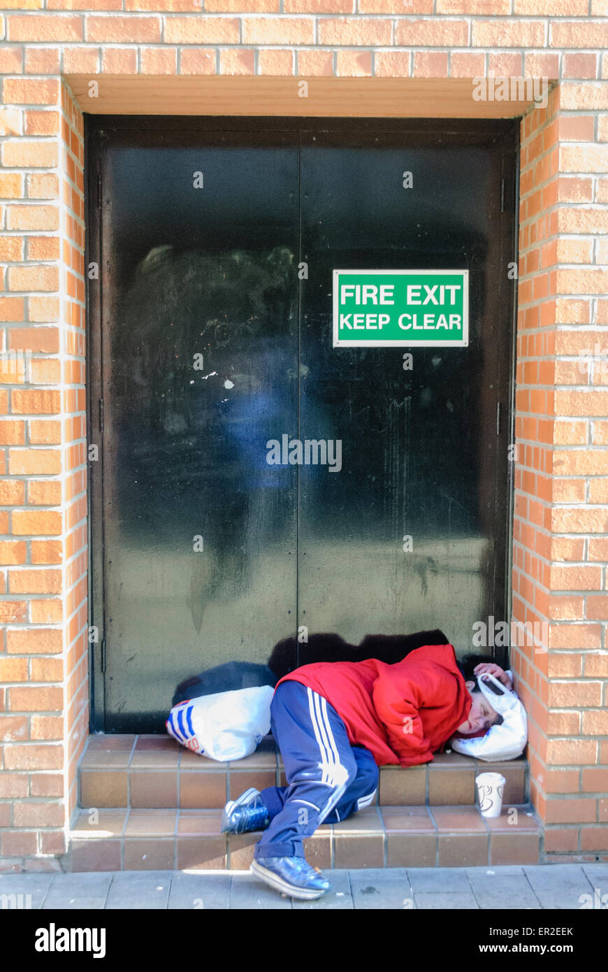 Senzatetto donna dorme in un negozio di porta Foto Stock