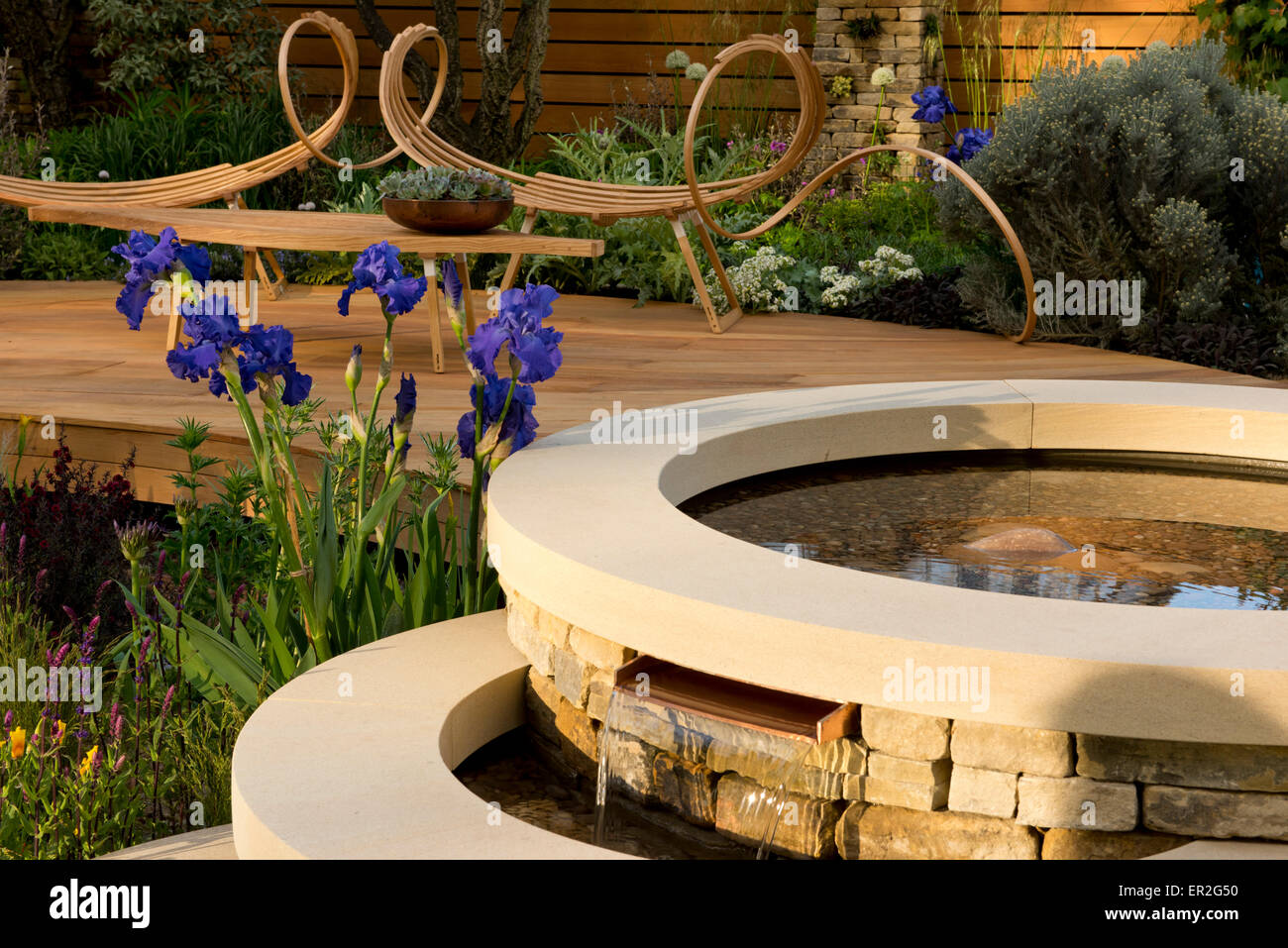 Un tiered fontana di pietra e iris blu in The Royal Bank of Scotland Garden al Chelsea Flower Show Foto Stock