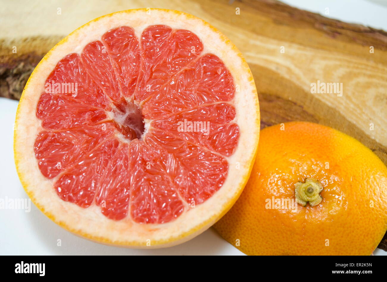 Fresco affettato pompelmo su una tavola di legno Foto Stock
