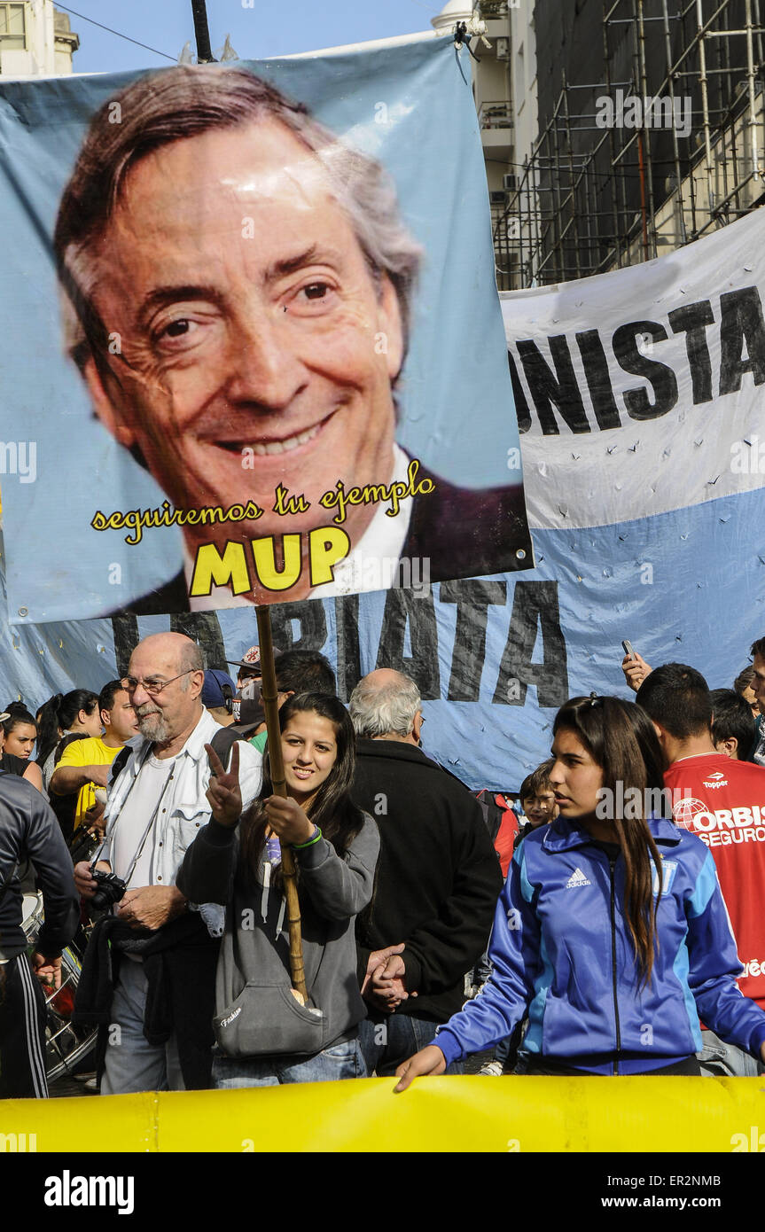 Buenos Aires, Buenos Aires, Argentina. 25 Maggio, 2015. Un membro di un gruppo politico che rende il segno V mentre si tiene un poster del tardo Presidente Nestor Kirchner con una leggenda la lettura ''faremo seguire il vostro esempio''. Centinaia di migliaia di persone si sono riuniti presso la Plaza de Mayo per commemorare il 205 anniversario della rivoluzione può essere il punto di partenza Argentina di guerra di indipendenza e di ascoltare il Presidente Cristina Fernandez Kirchner il maggio scorso 25 Discorso dopo 8 anni in ufficio. Credito: Patricio Murphy/ZUMA filo/Alamy Live News Foto Stock