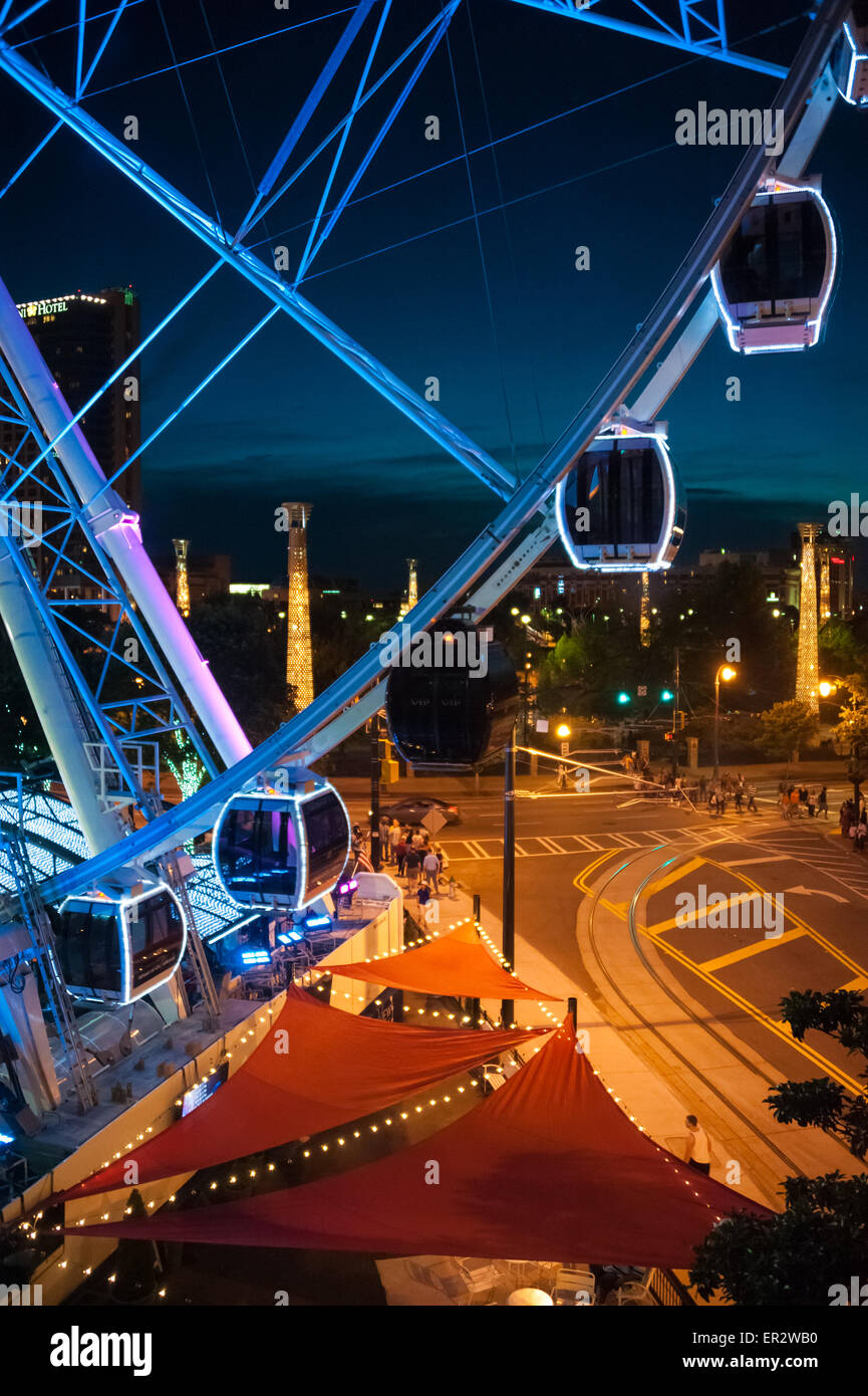 Atlanta, Georgia skyline serale con il colorfully SkyView illuminato ruota panoramica Ferris e colonne di tipo iconico di Centennial Olympic Park. Foto Stock