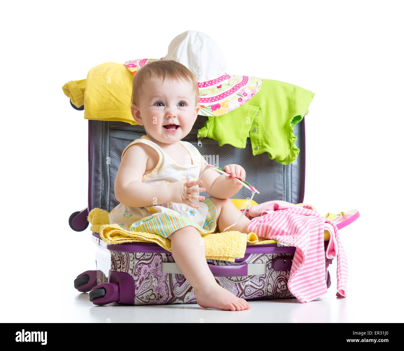 Il Toddler ragazza seduta in valigia con le cose per vacanze viaggi isolato Foto Stock