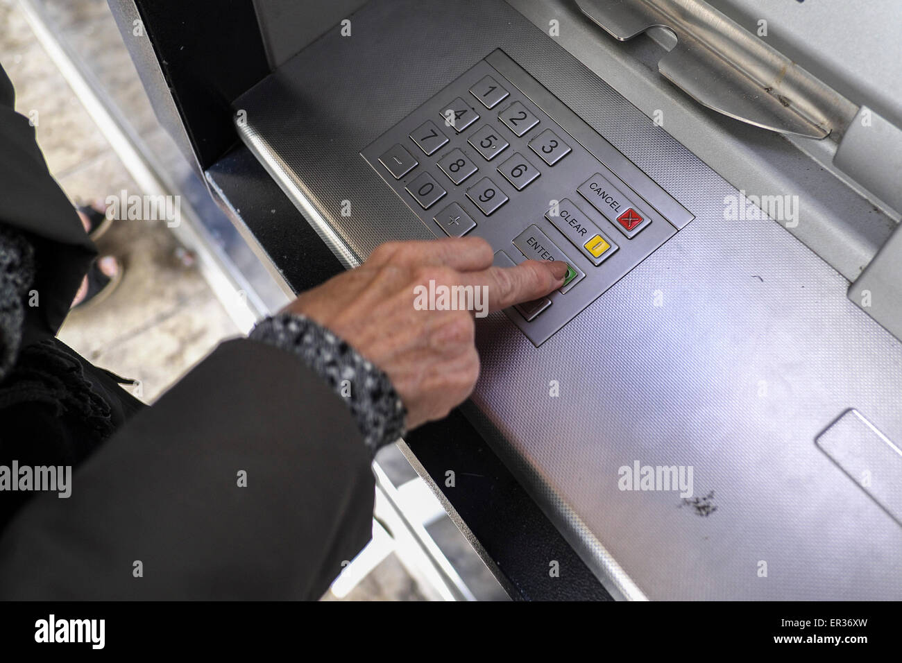 Un cliente di effettuare transazioni presso un bancomat. Foto Stock