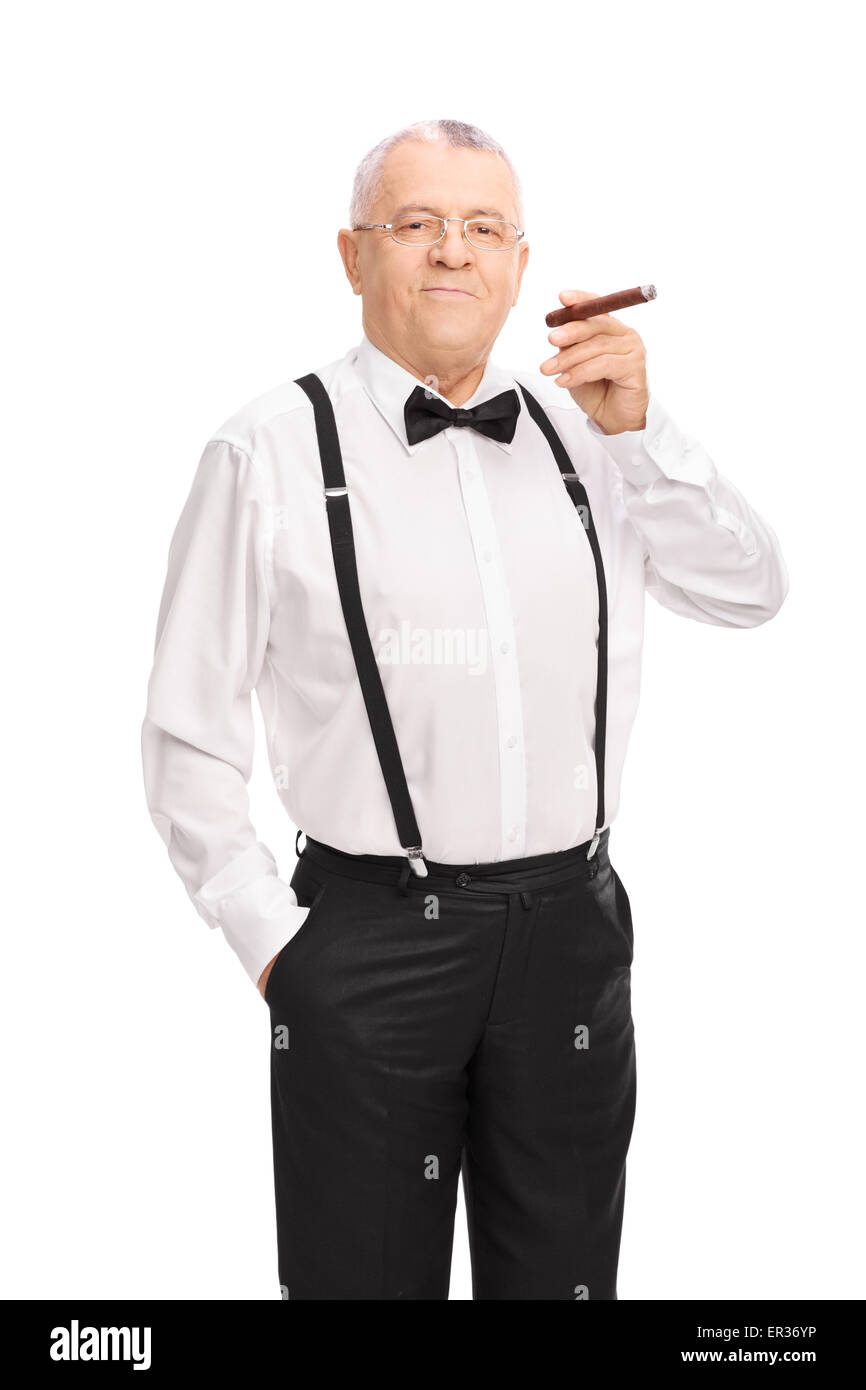 Colpo verticale di un elegante gentleman senior di fumare un sigaro e guardando la telecamera isolata su sfondo bianco Foto Stock