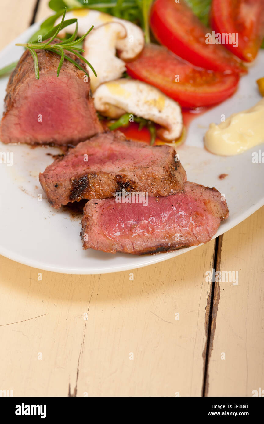 Filetto di manzo alla griglia di mignon con verdura fresca sul lato ,funghi pomodoro e insalata di rucola Foto Stock