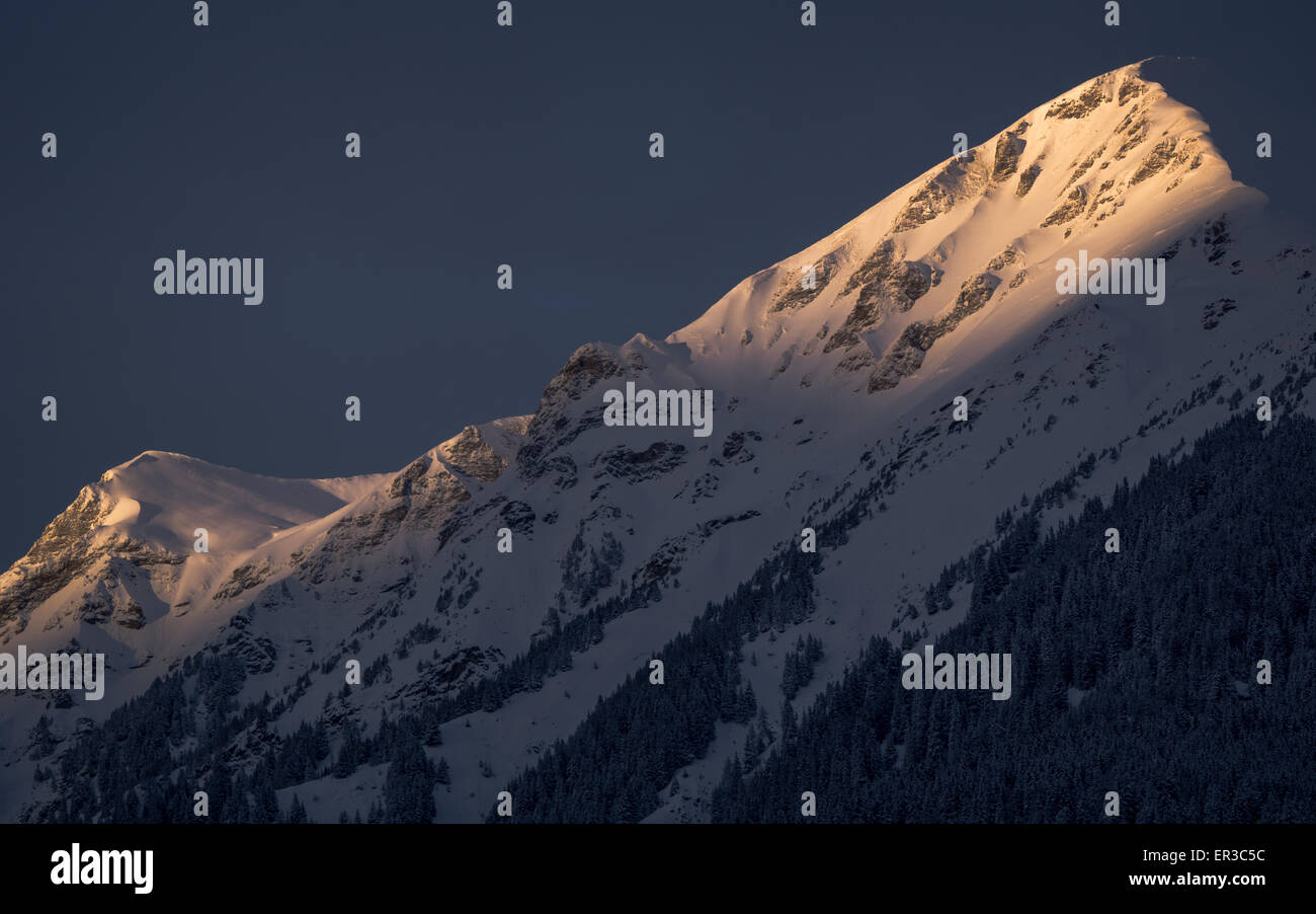 Montagne coperte di neve nell'ultima luce del giorno Foto Stock
