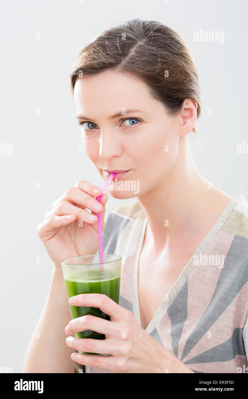 Donna bere un grano succo di erba. Foto Stock