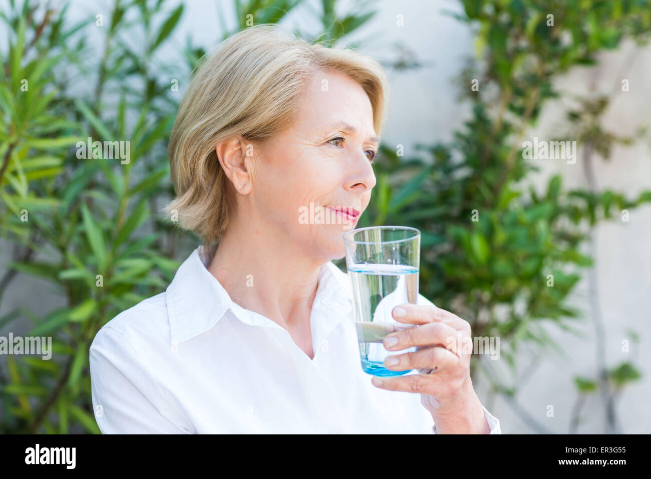 Donna di bere un bicchiere di acqua. Foto Stock