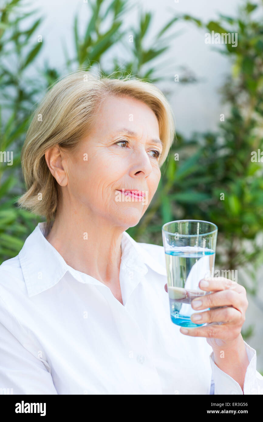 Donna di bere un bicchiere di acqua. Foto Stock