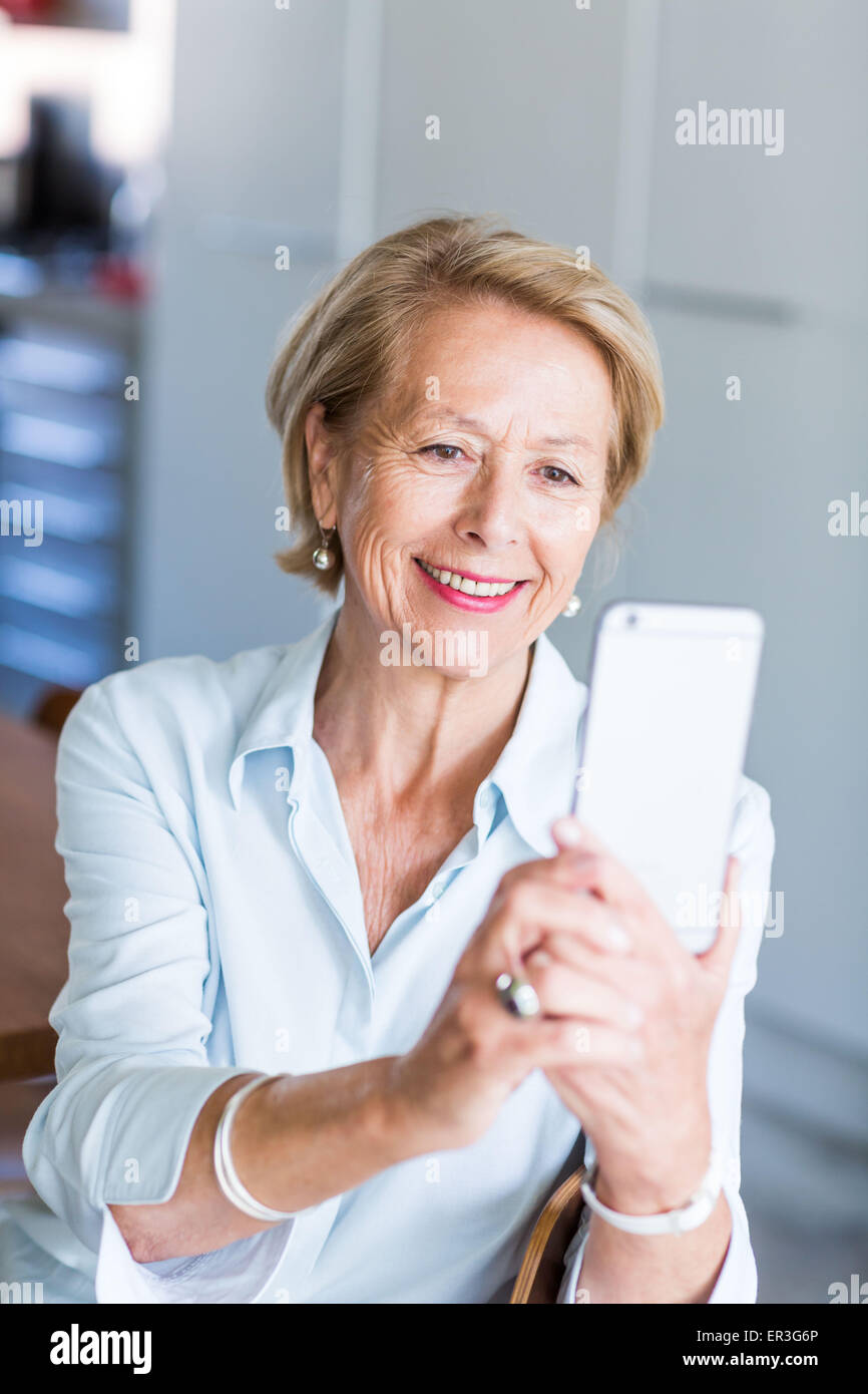Donna che utilizza un iphone®. Foto Stock