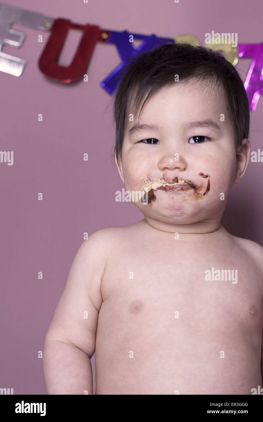 Bambino con faccia sporca dopo aver mangiato torta Foto Stock