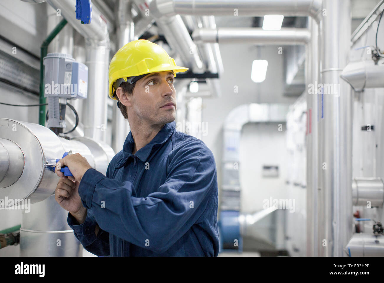 Operaio specializzato al lavoro in stabilimento industriale Foto Stock